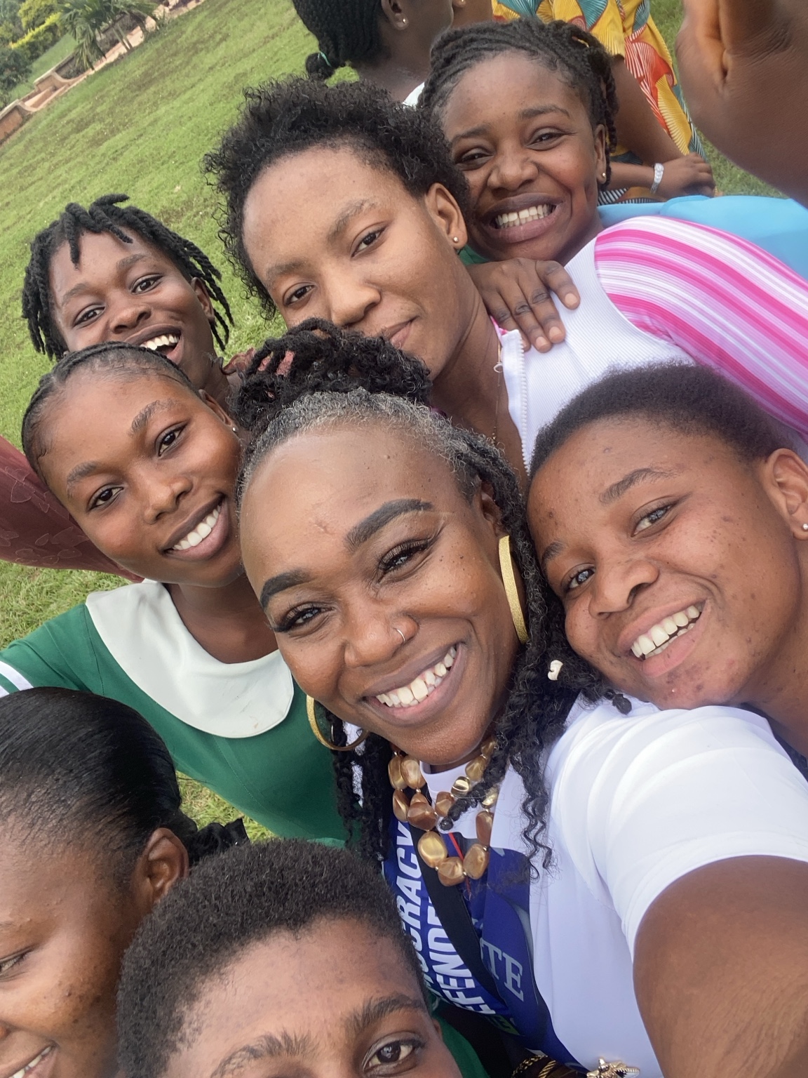 Marsita smiling with a group of girls during her work in Ghana